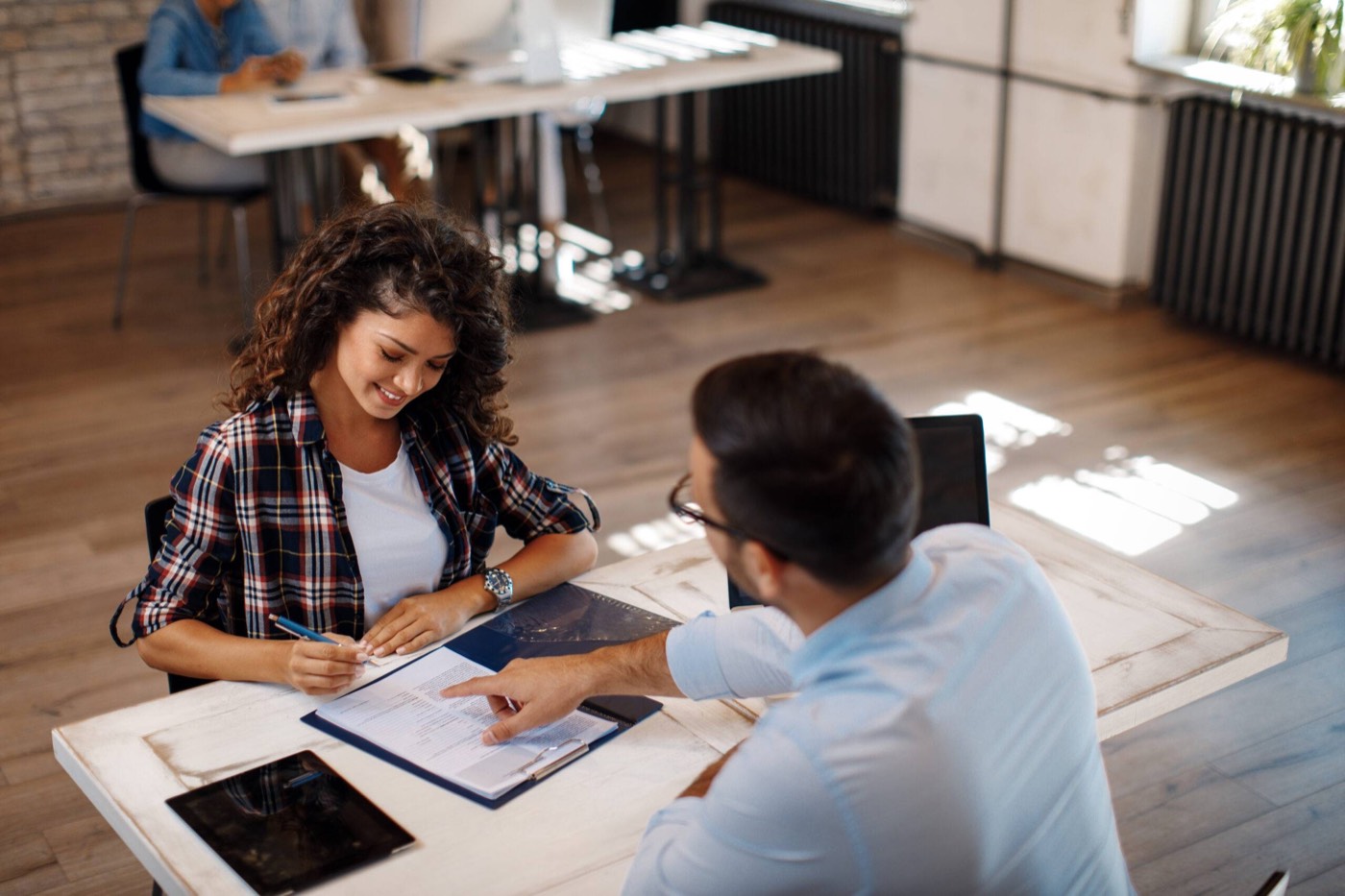 A signing agent going through a loan package with borrowers at a table