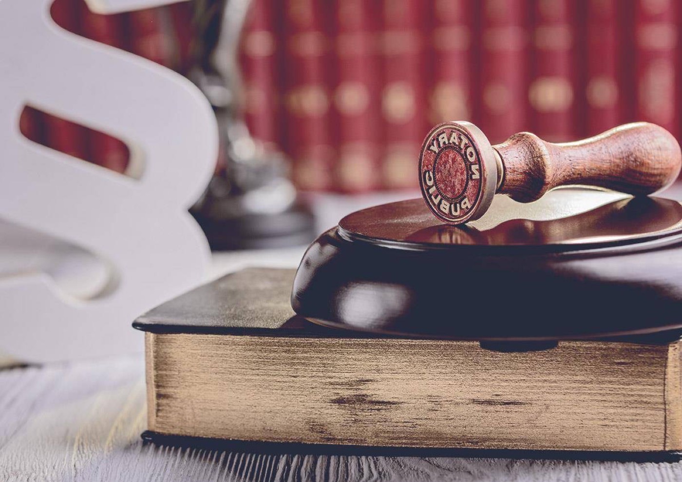 A wax seal and stamp resting on an old bound document